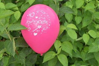 A delicate pink bubble balloon with a personalized message floating gently.