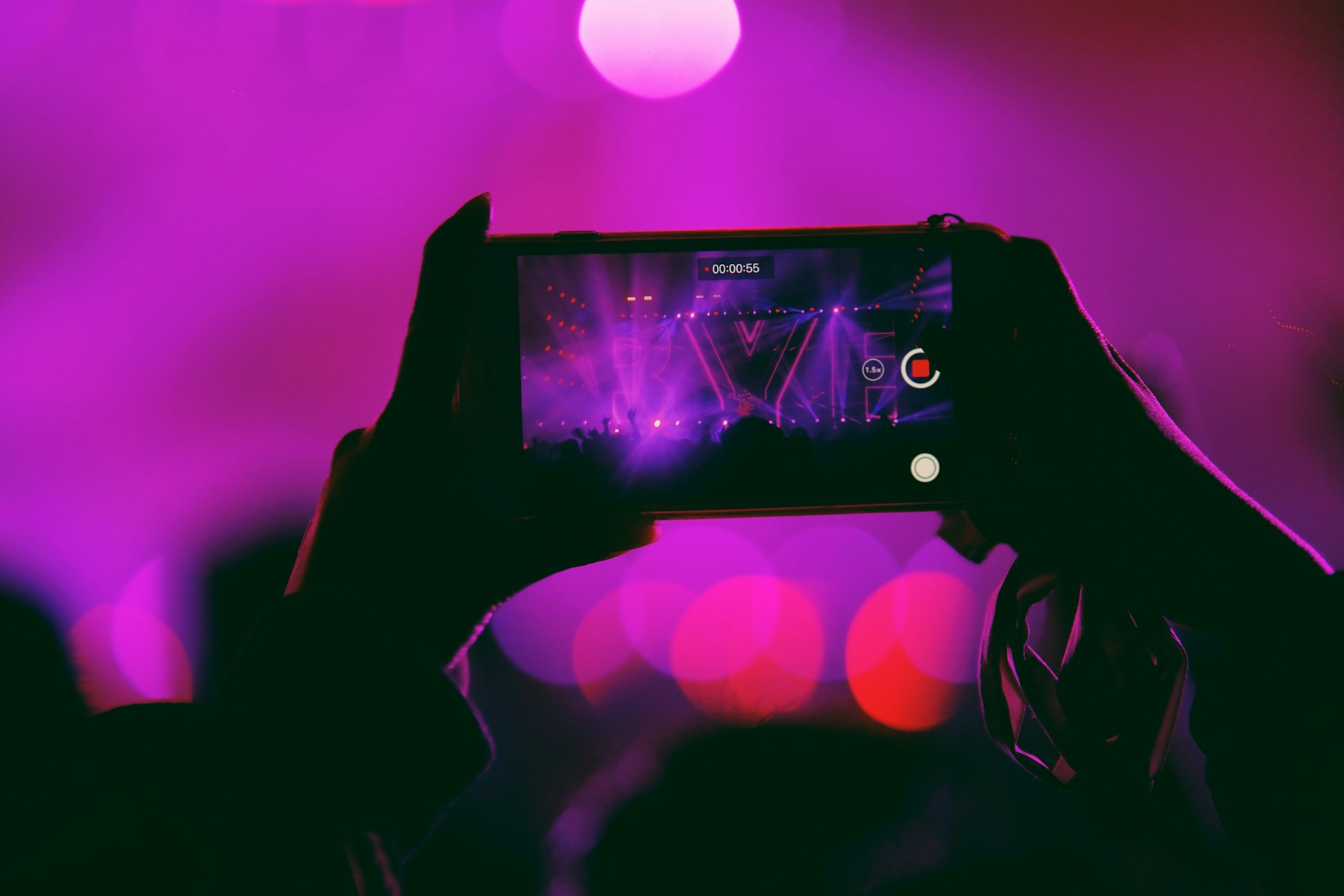 person taking photo of studio with pink strobe lights