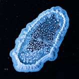Close-up of a colorful animated mitochondrion glowing against a dark background.