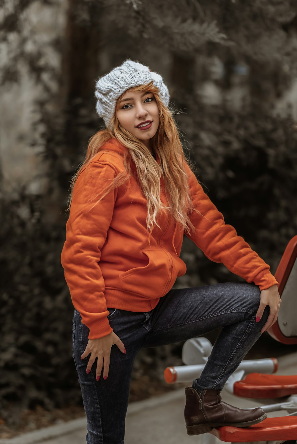 woman in orange jacket standing beside vehicle