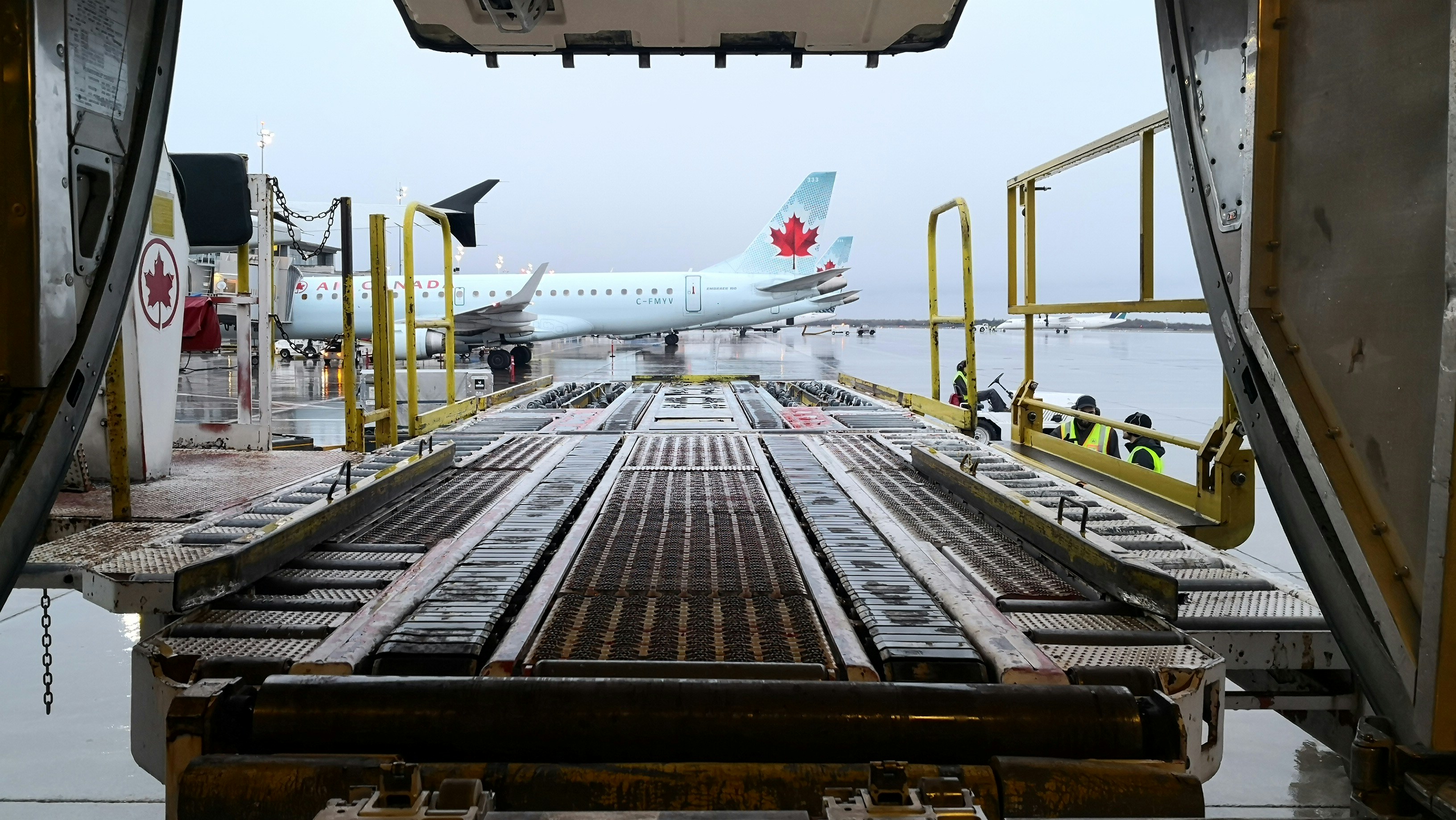Aviones en la pista del Aeropuerto de Ottawa desde la bodega de carga de otro avión [Foto: Sal Karaguli/Unsplash]