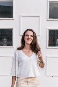 Friendly woman with glasses standing next to architectural models on a desk.