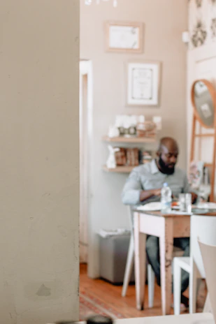 A cheerful customer enjoying a homemade meal at a cozy kitchen table with warm lighting.