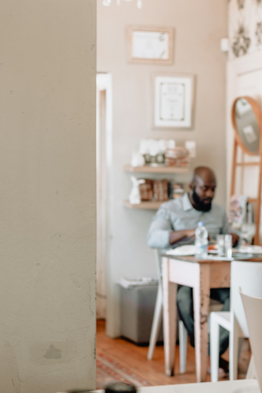 selective focus photo of man sitting on chair in front of white and brown table