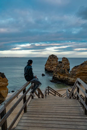 man sitting on brown fence