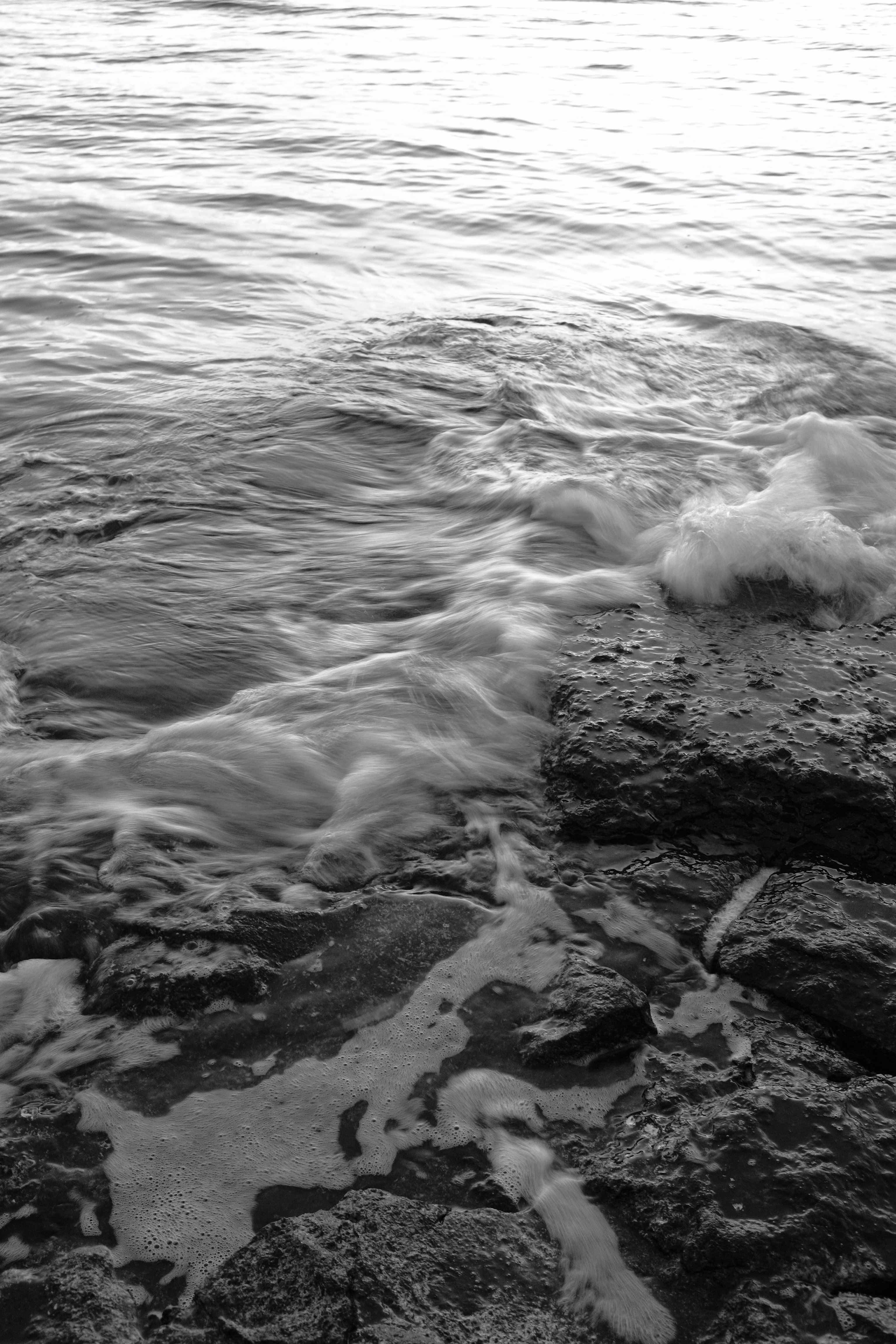 grayscale photo of waves rushed to shore