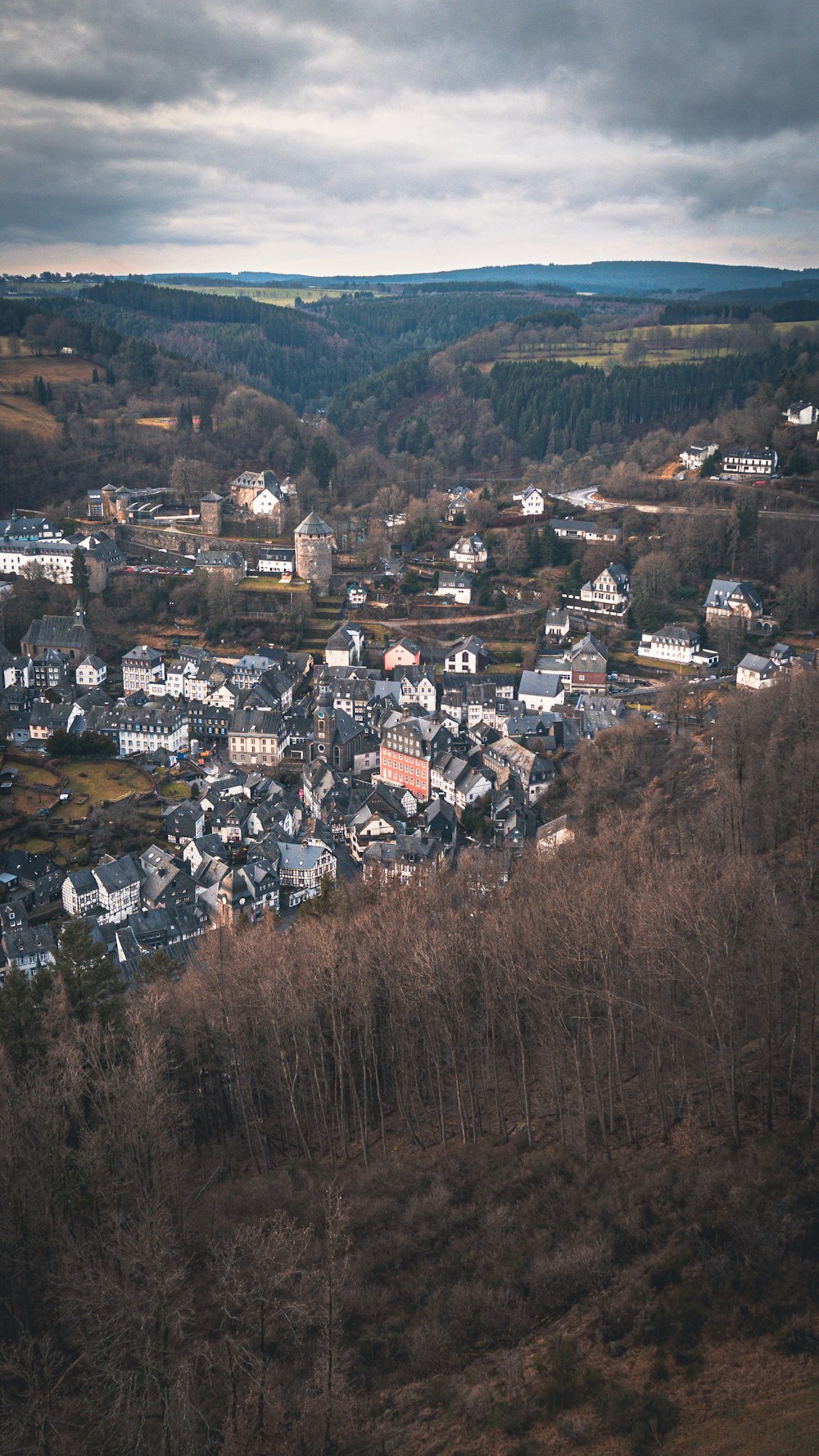 a small town nestled on a hill in the middle of a forest