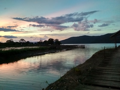 A serene view of Waduk Jatiluhur at sunset with calm waters reflecting the sky