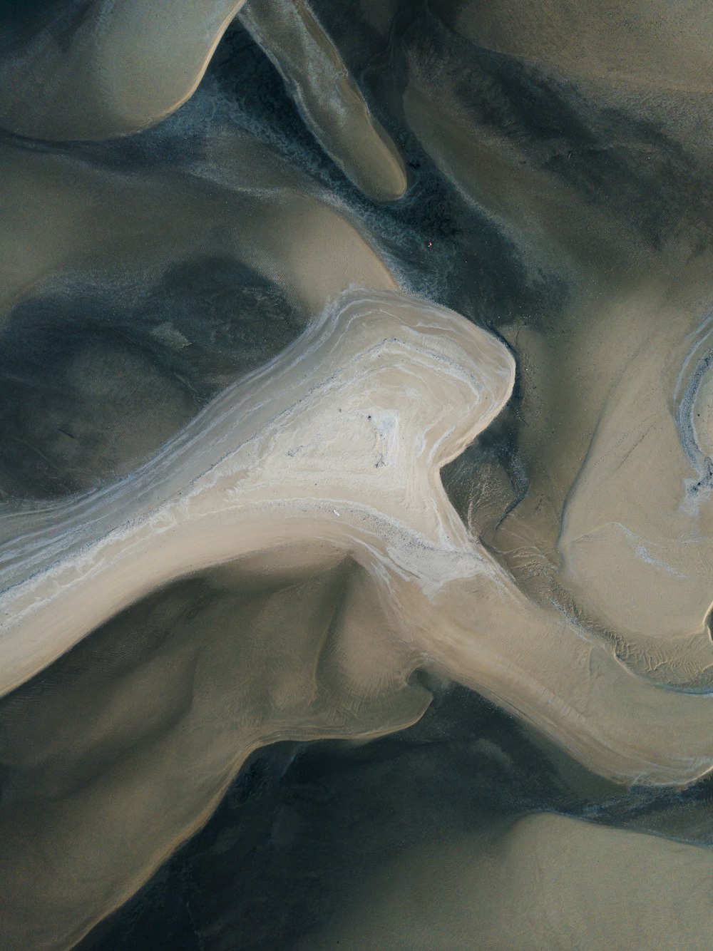 an aerial view of a sandy area with a river running through it