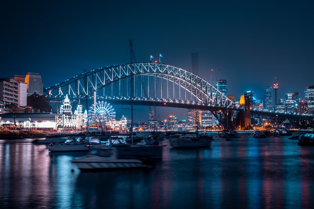 gray concrete bridge over river near buildings with lights