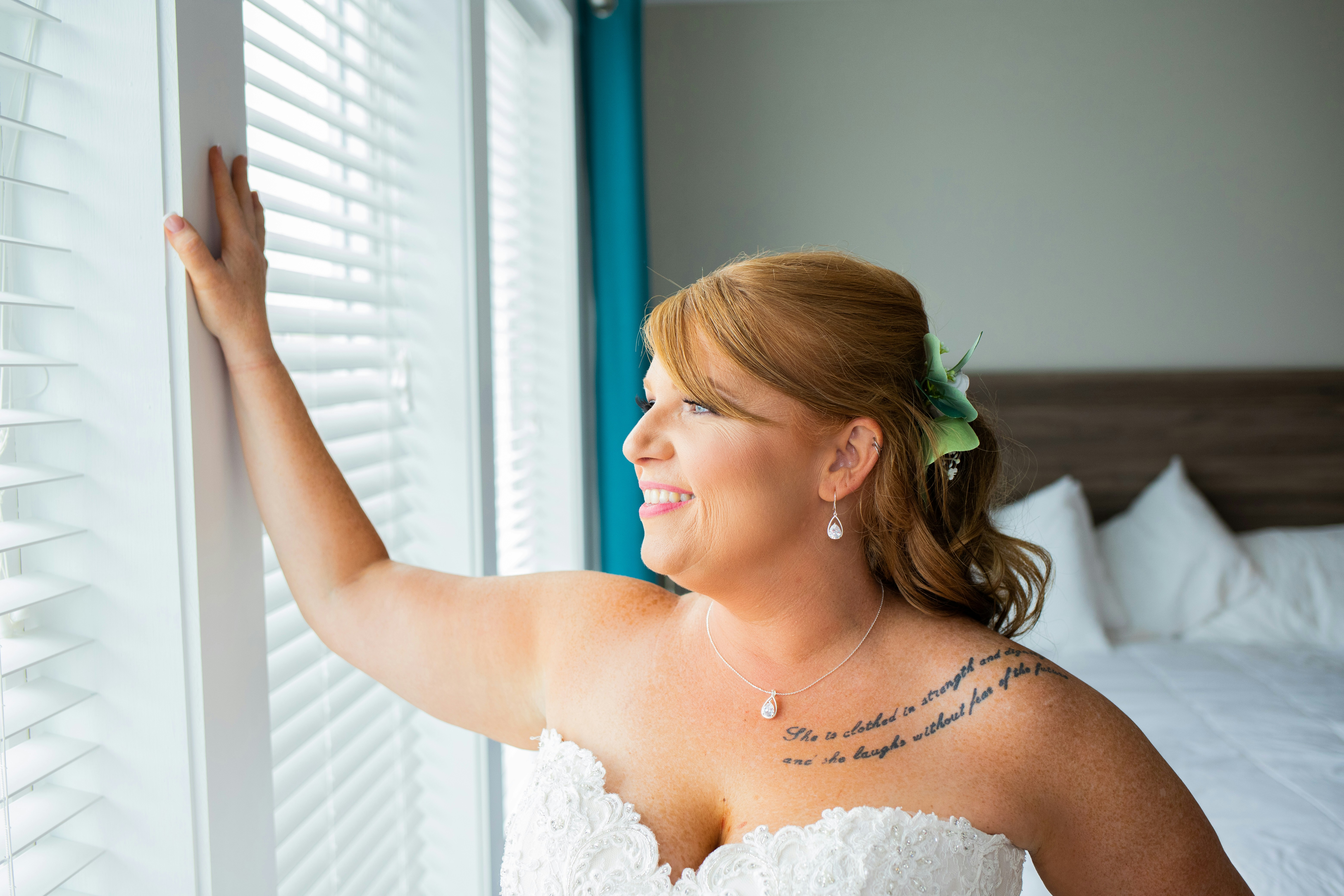 a woman in a wedding dress looking out a window