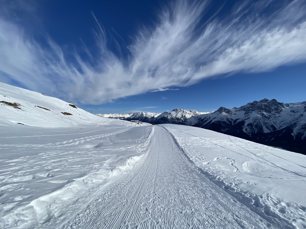Una pista de esquí cubierta de nieve con montañas al fondo