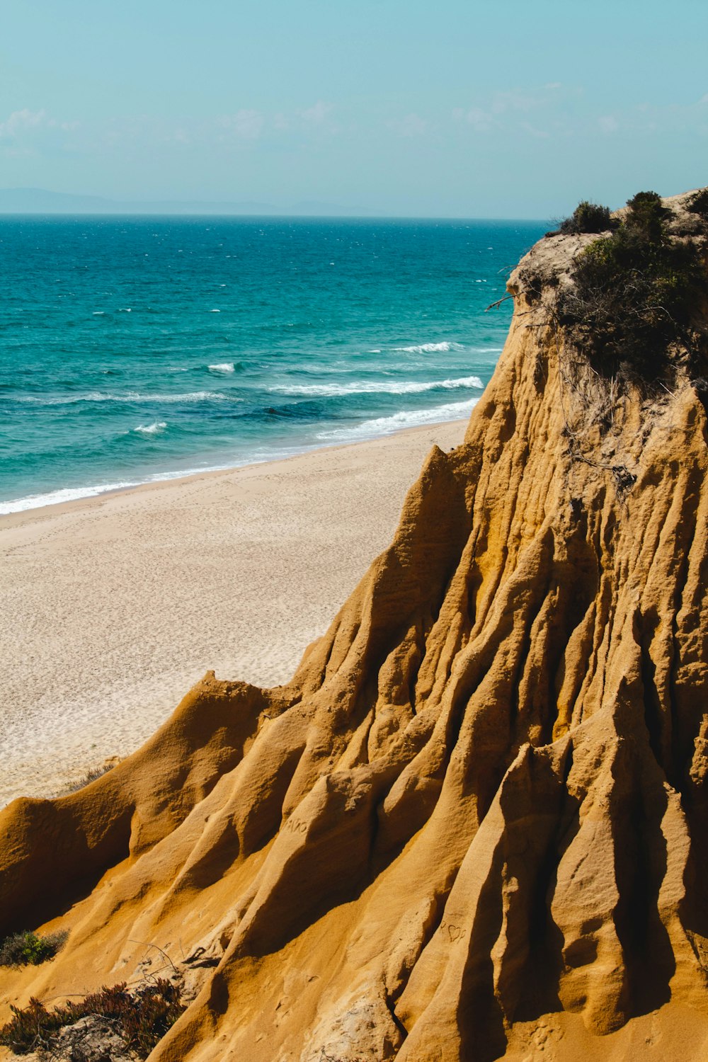 Ein Sandstrand am Meer unter blauem Himmel