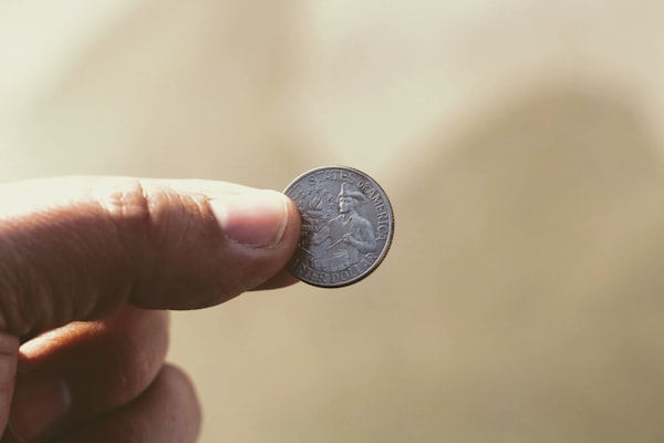 a hand holding a quarter