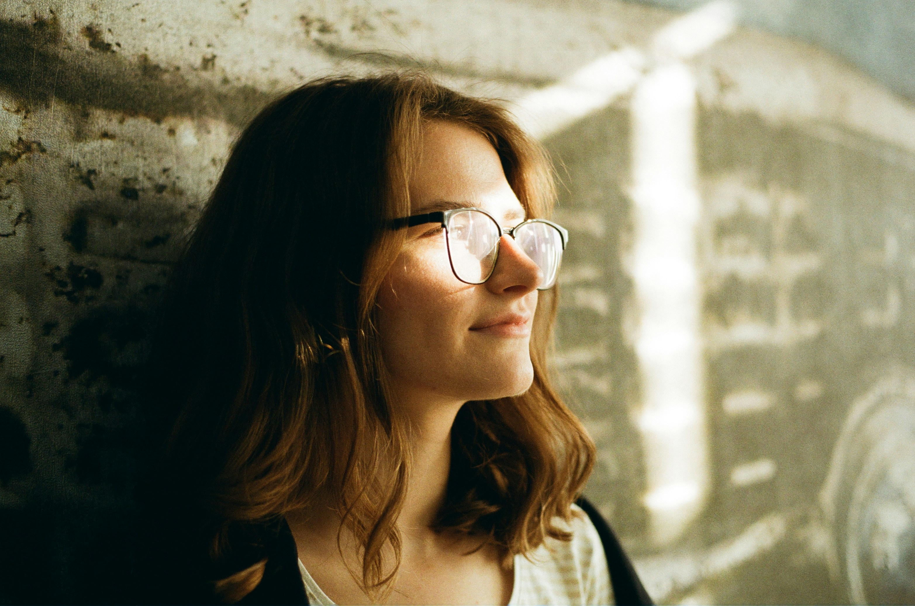 Woman smiling against wall