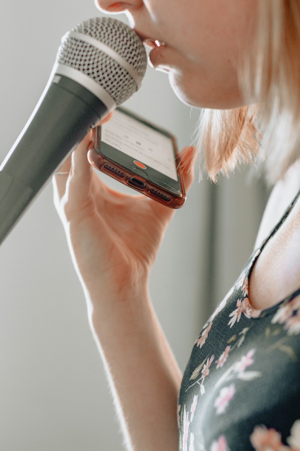 woman holding iPhone with microphone on mouth