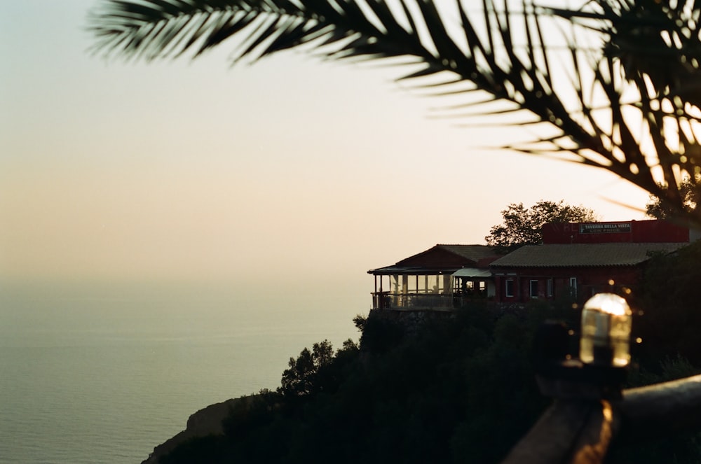 a house sitting on top of a cliff next to the ocean