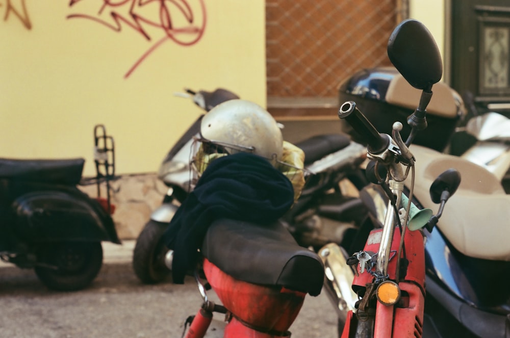 a red scooter parked next to a yellow building