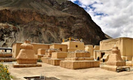 few people near historic world heritage site viewing mountain under white and blue sky