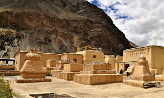 few people near historic world heritage site viewing mountain under white and blue sky