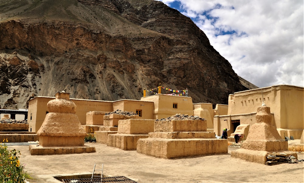 few people near historic world heritage site viewing mountain under white and blue sky