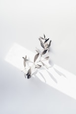 a group of metal leaves sitting on top of a white surface