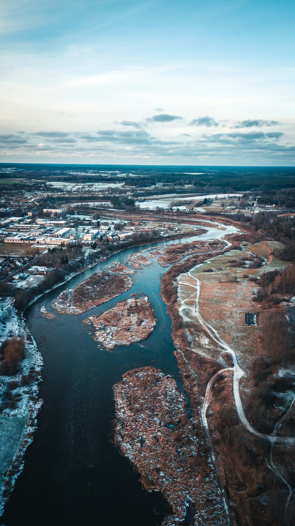 aerial photography of houses and buildings near body of water under blue and white sky