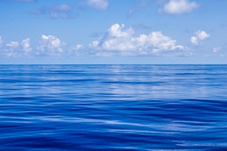 blue body of water under white and blue sky