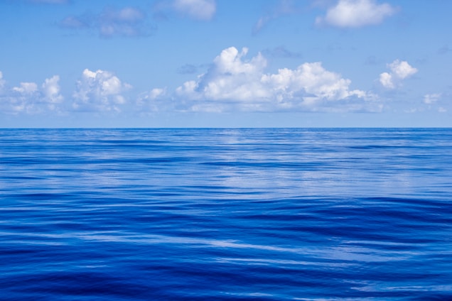 blue body of water under white and blue sky