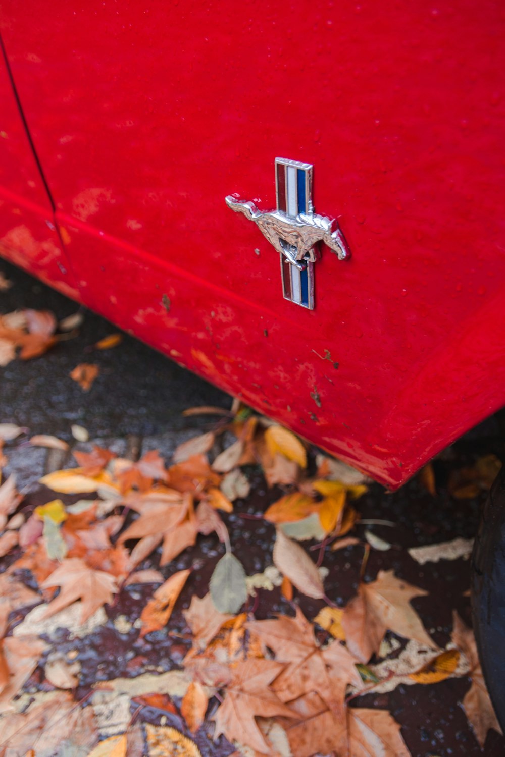 parked red Ford Mustang during daytime