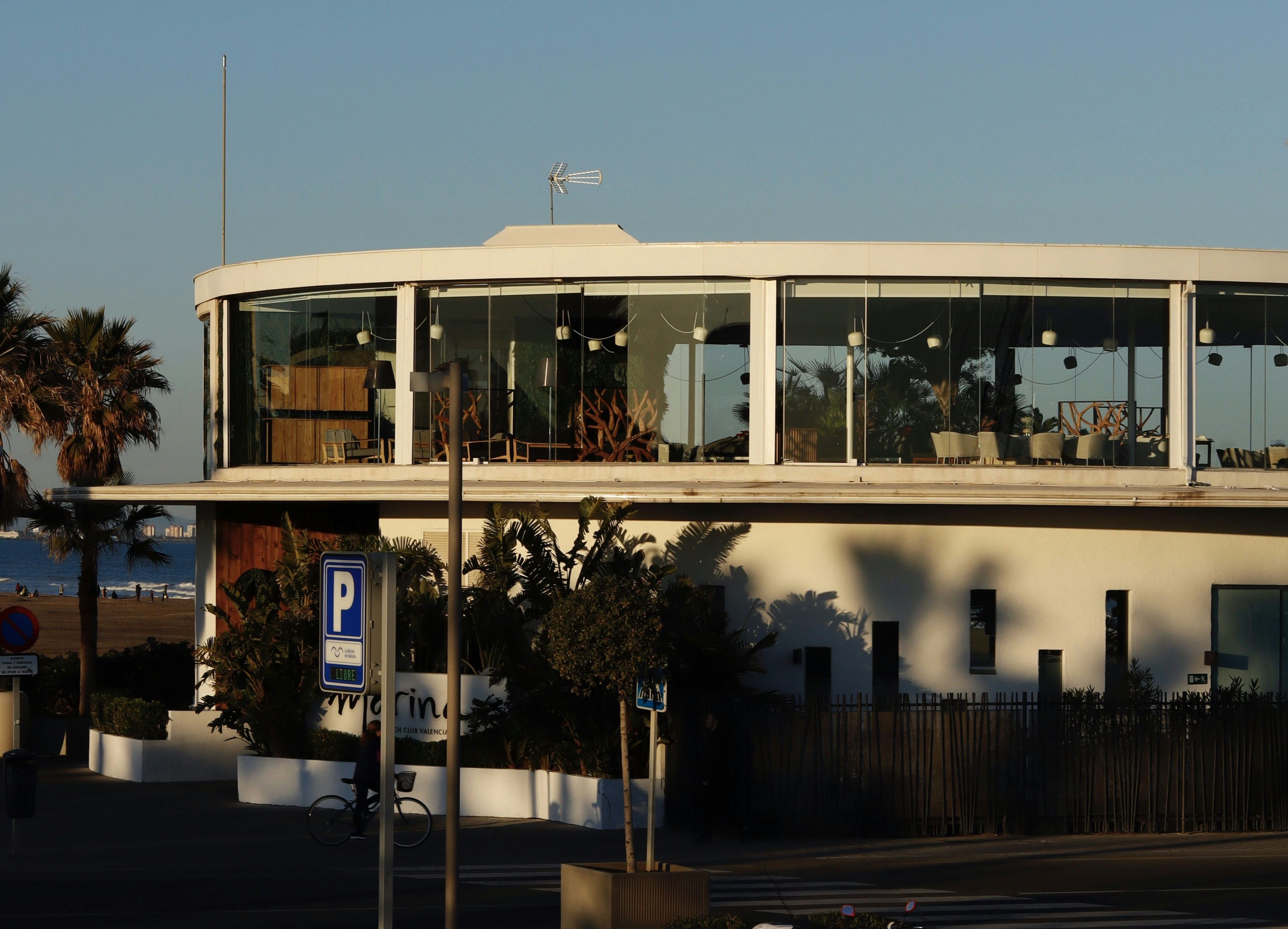 white glass walled building near body of water during daytime