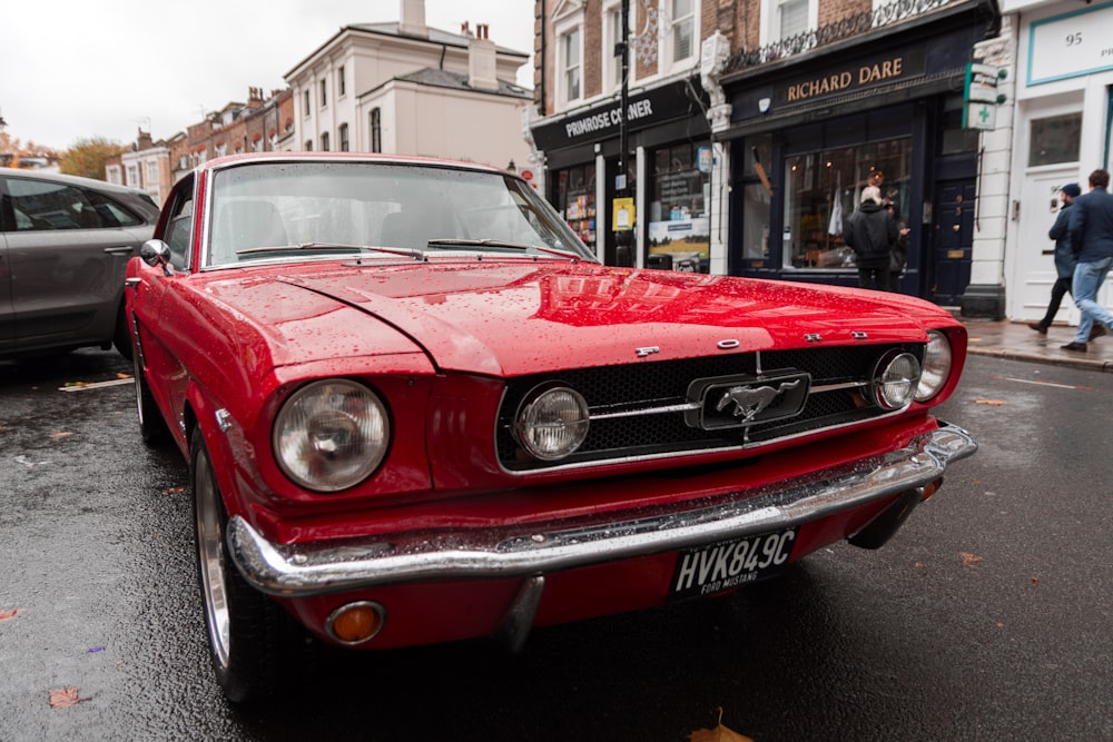 red first generation Ford Mustang coupe parking near road