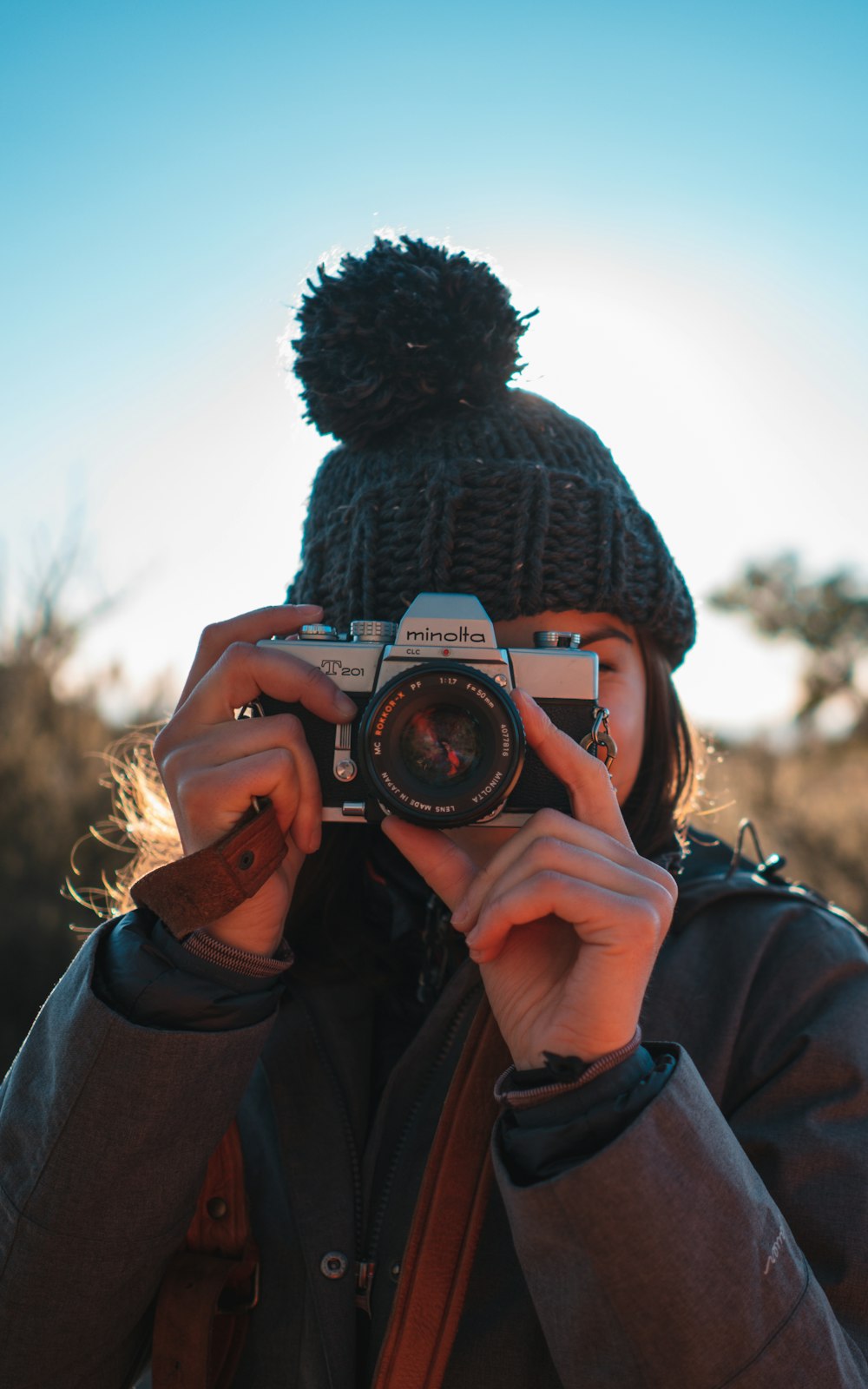 woman using SLR camera during daytime