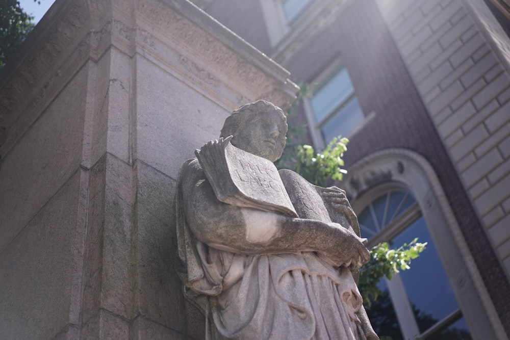 man holding open book statue
