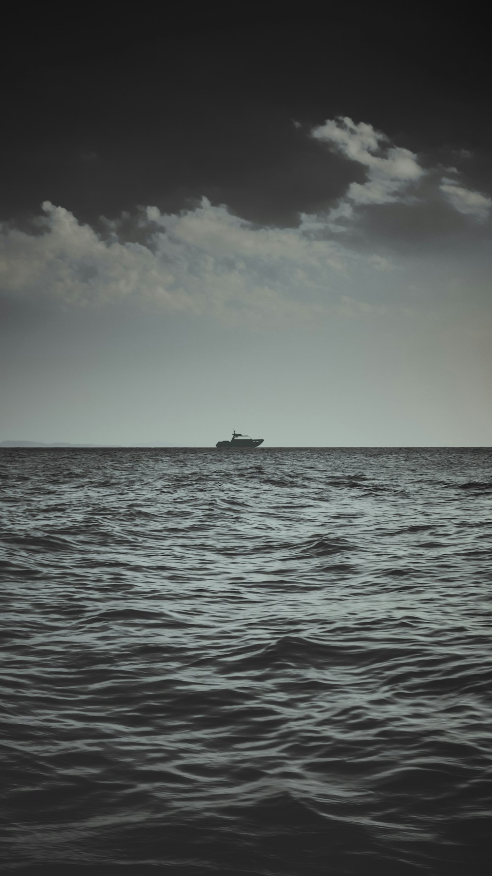 Graustufenfotografie eines Bootes auf einem Gewässer