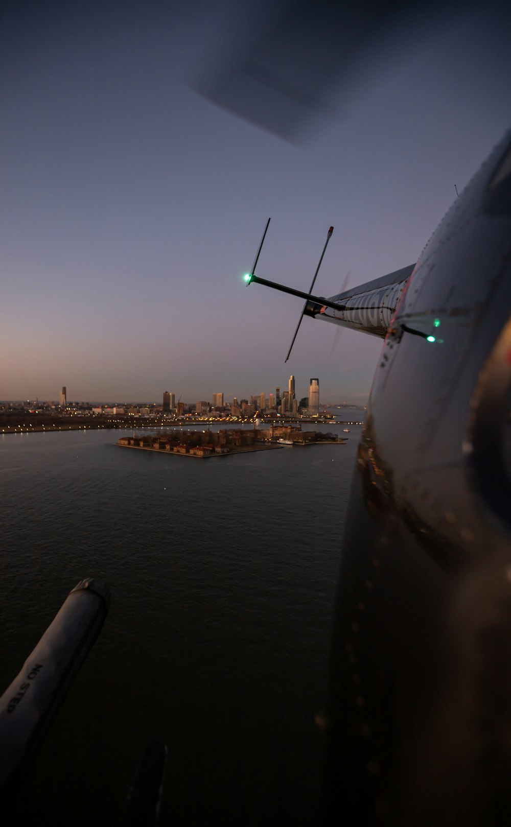 shallow focus photo of white helicopter flying above body of water during nighttime