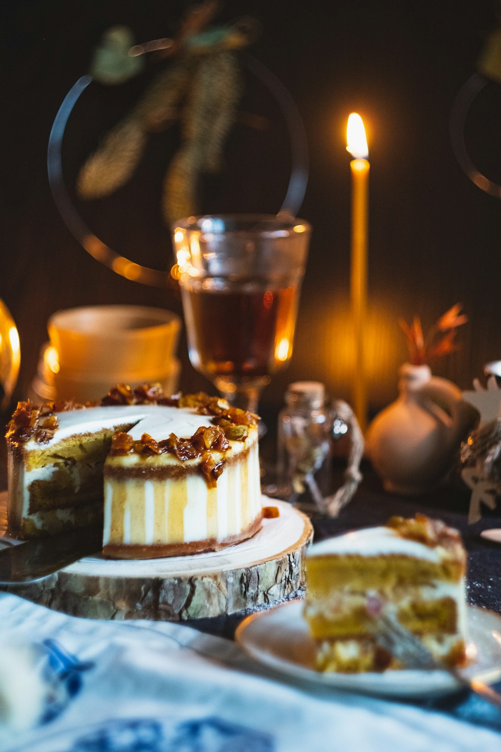 macro photography of sliced cake near glass cup and candle