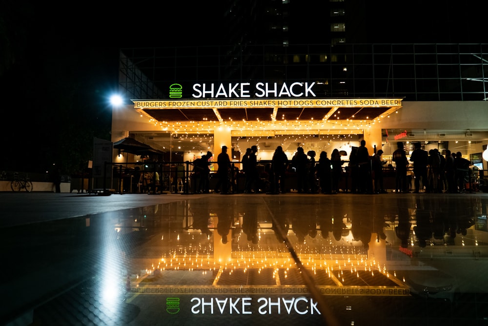 people standing and gathering near Shake Shack building during night time