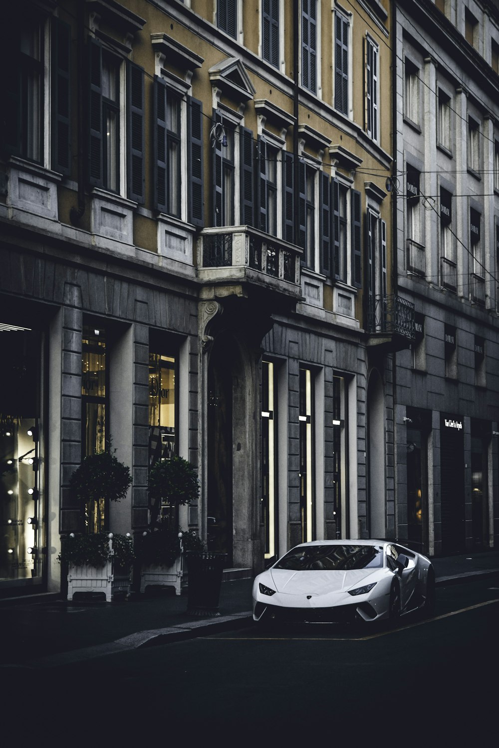 white sports car parking near road beside buildings