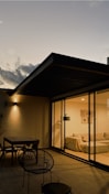 square gray wooden table outside glass house during night time