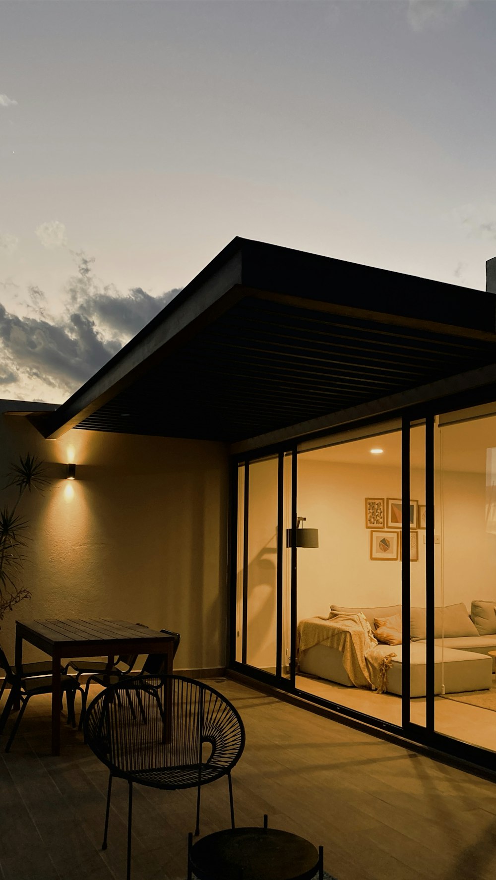 square gray wooden table outside glass house during night time