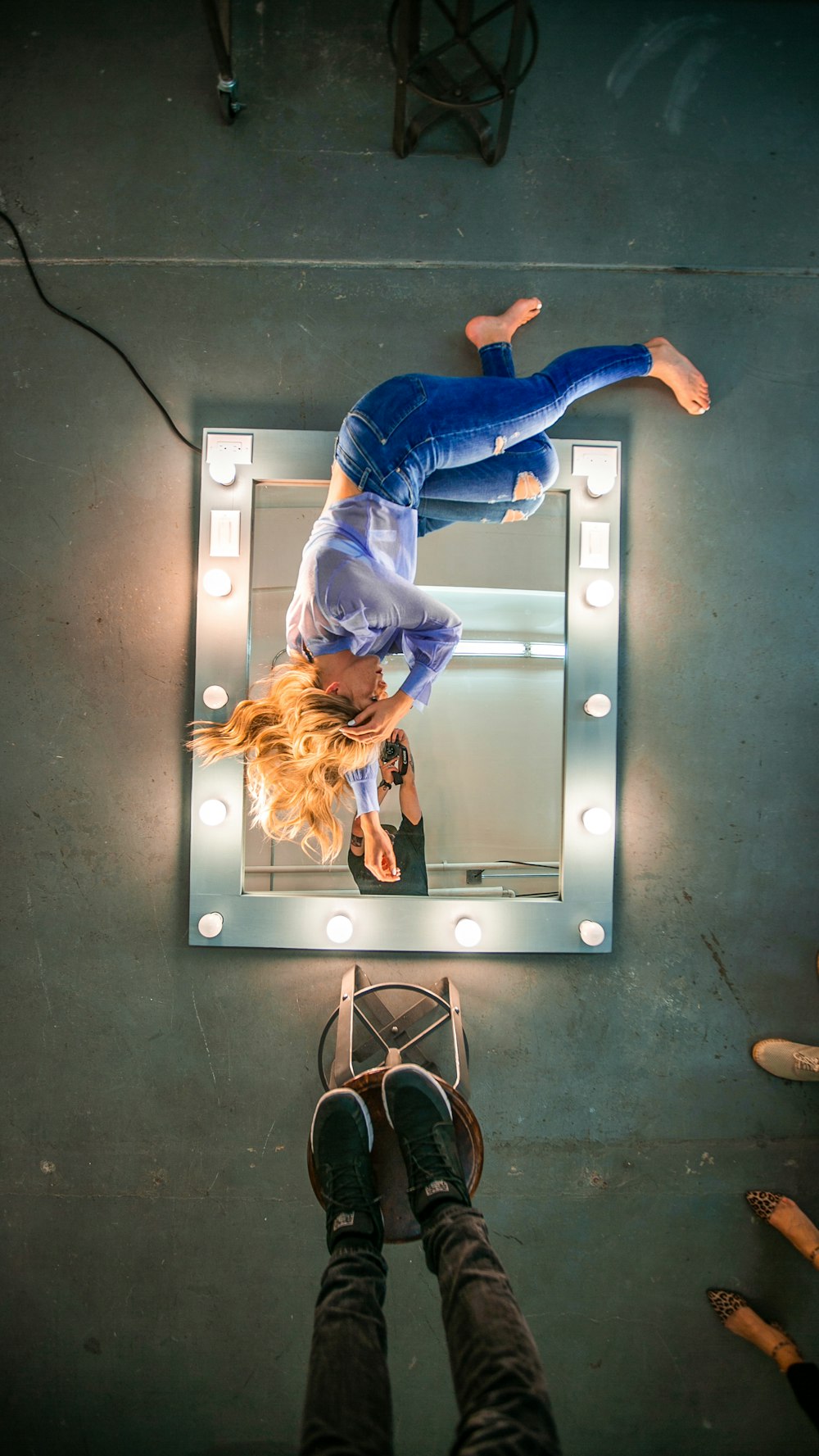 woman lying on mirror with lights