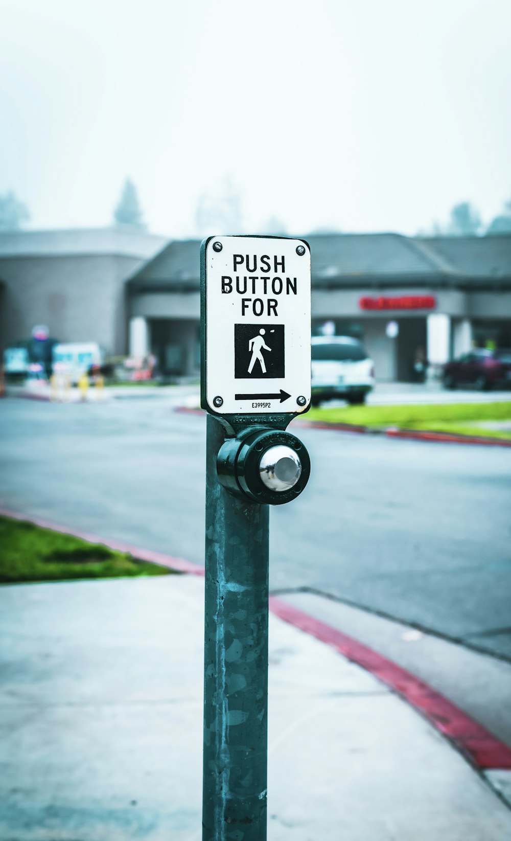 push button for walk post beside the road during daytime