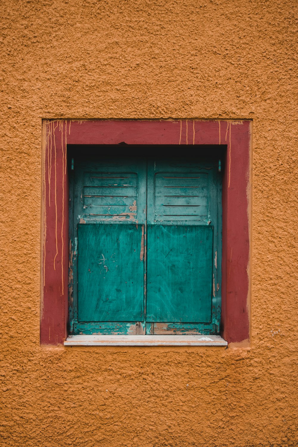 orange building with closed green wooden window