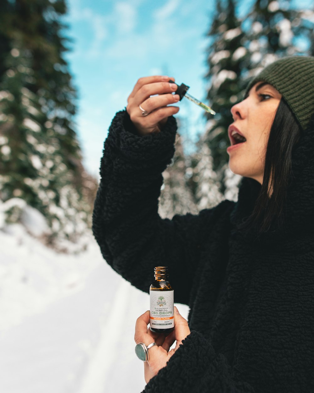 woman using drop bottle near her mouth