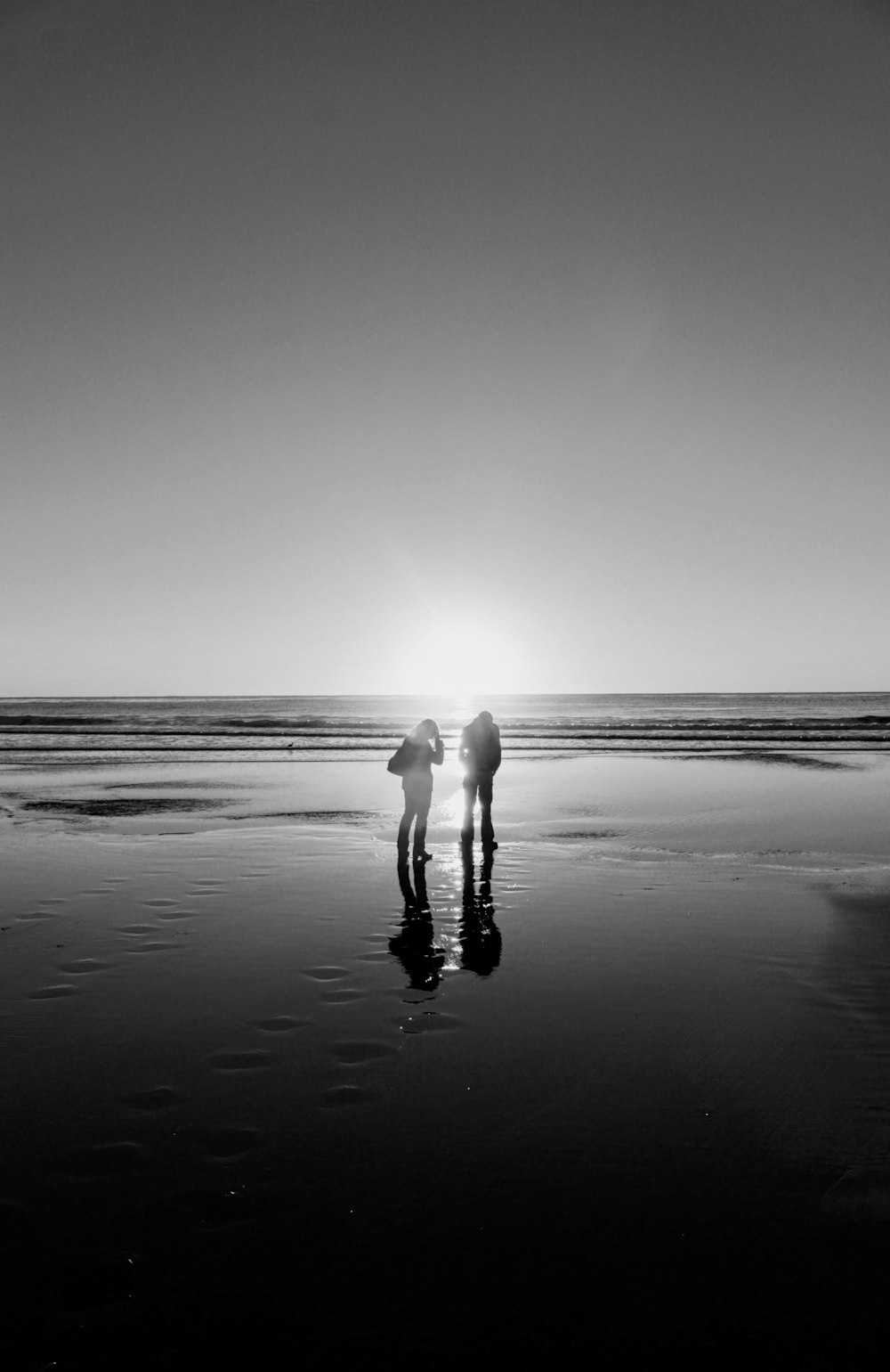 two people standing on seashore during day
