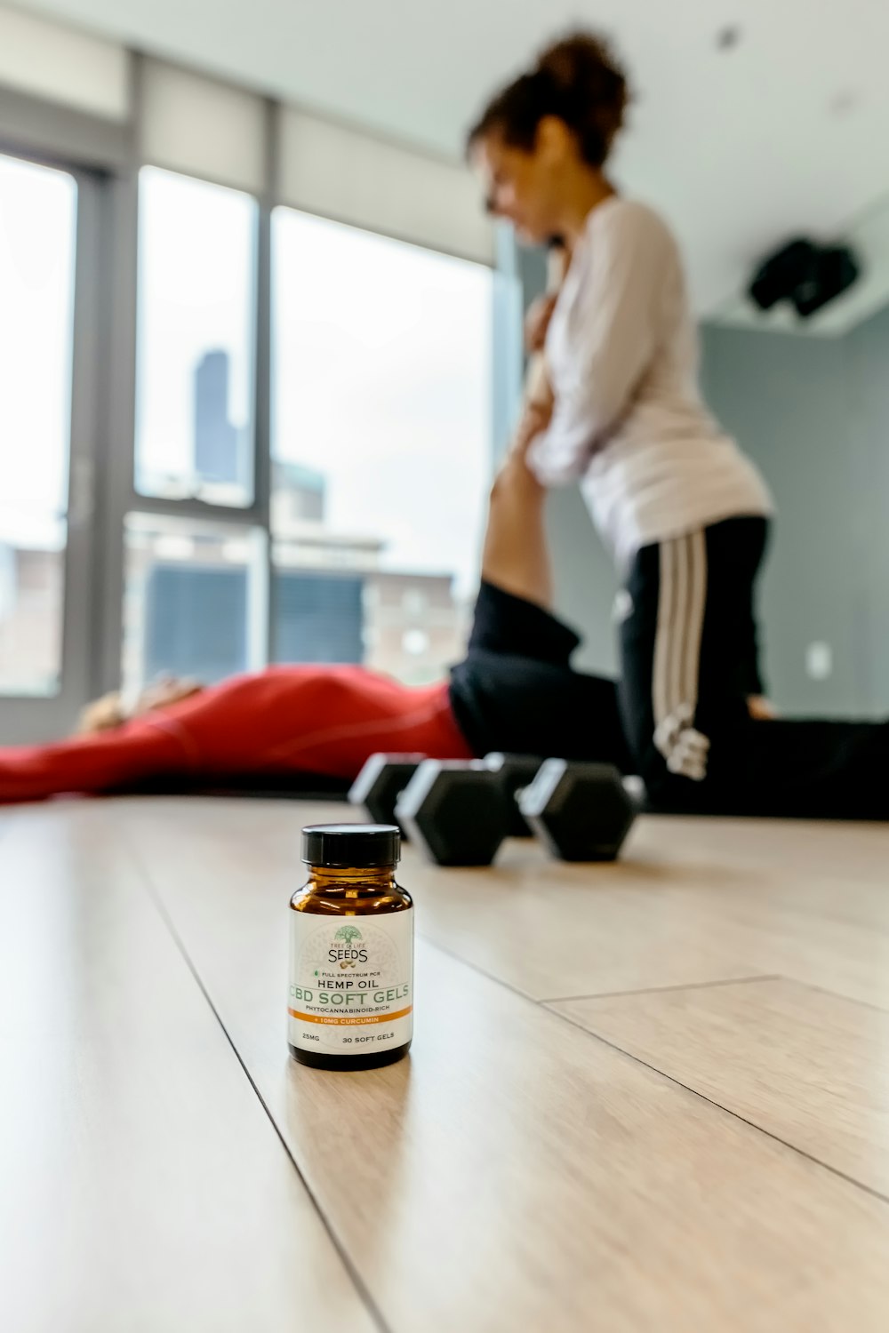 bottle near barbells and two people exercising