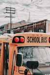 yellow school bus near building under white and blue sky
