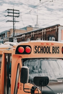 yellow school bus near building under white and blue sky