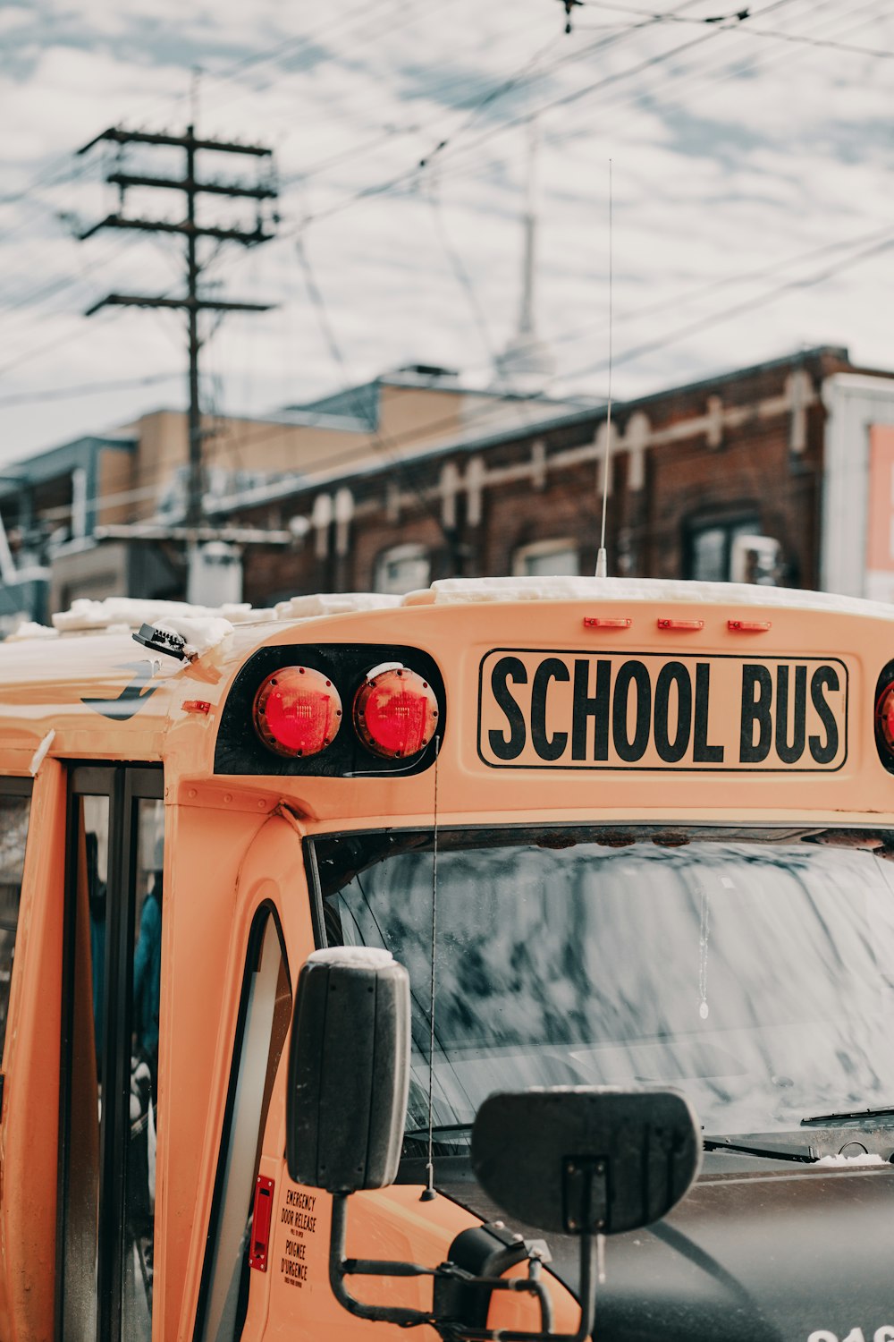 yellow school bus near building under white and blue sky